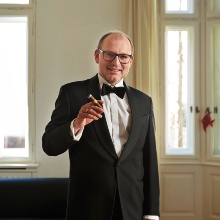 Christian Hesse standing with tuxedo and a cigar in his right hand